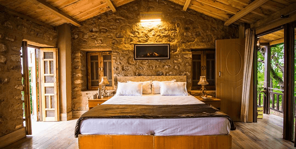 Cozy stone bedroom with warm lighting and balcony access